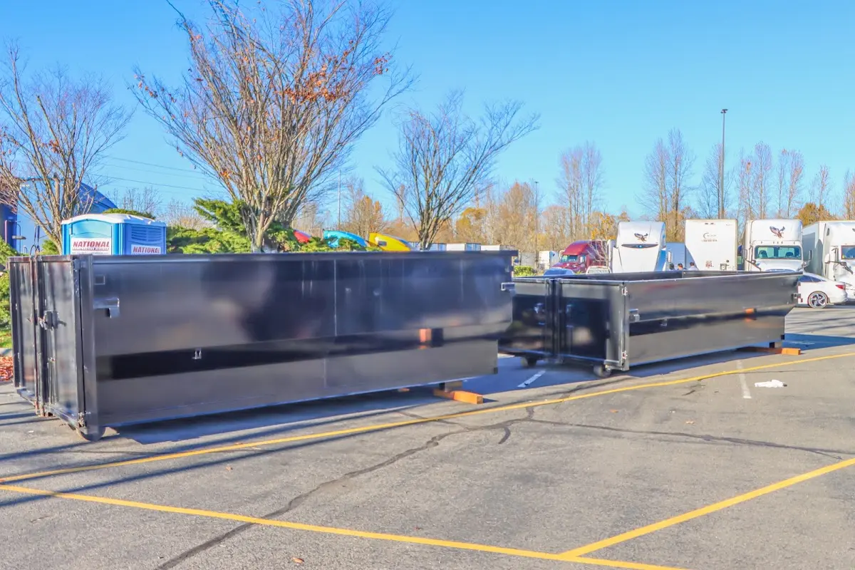 Professional dumpster rental service with roll-off container on residential driveway in LaBelle